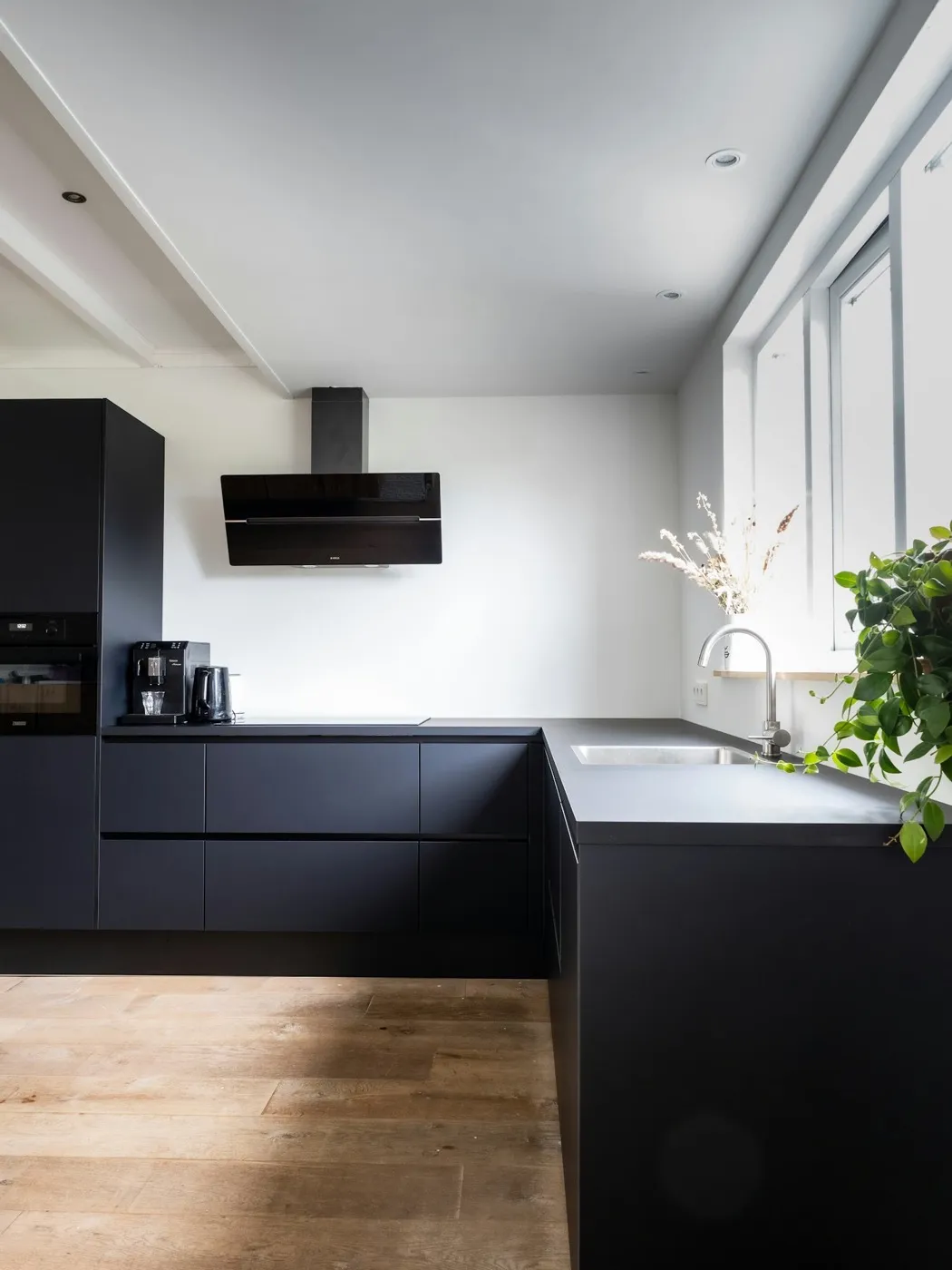 A handsome dark, modern kitchen built by Sevenday Kitchen Co.